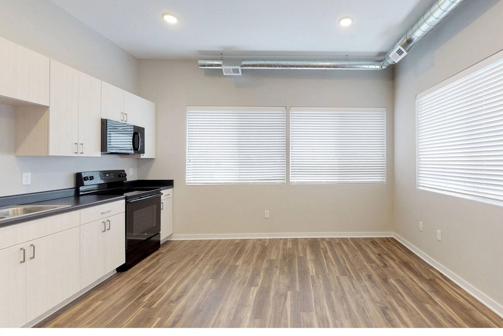 a kitchen with white cabinets and a stove and a window at Vue Apartments, Iowa