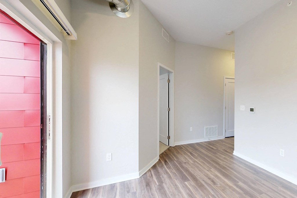 A room with a white door and a window with a red shade at Vue Apartments, Des Moines, IA 50309