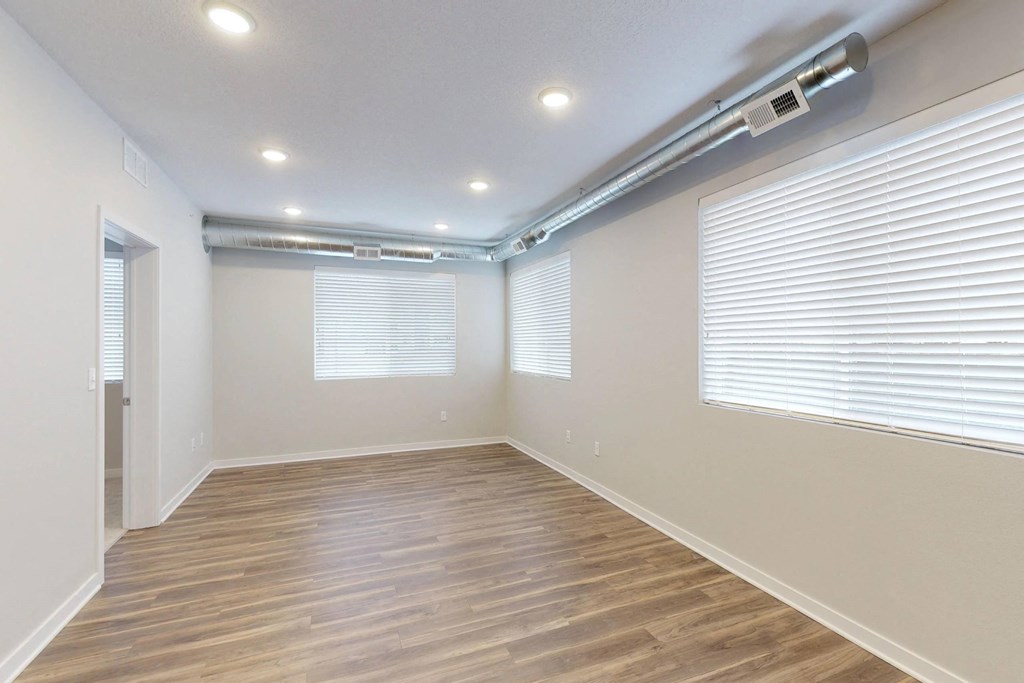 a living room with a hard wood floor and a large window at Vue Apartments, Des Moines, IA