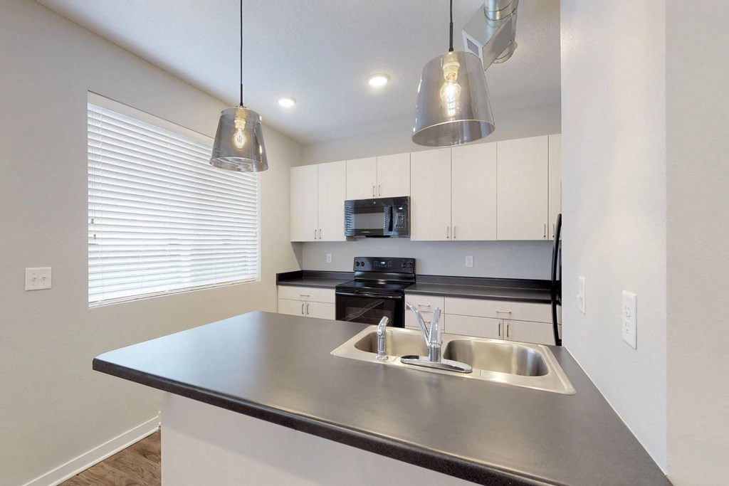 A modern kitchen with a stainless steel sink and countertop at Vue Apartments, Iowa, 50309
