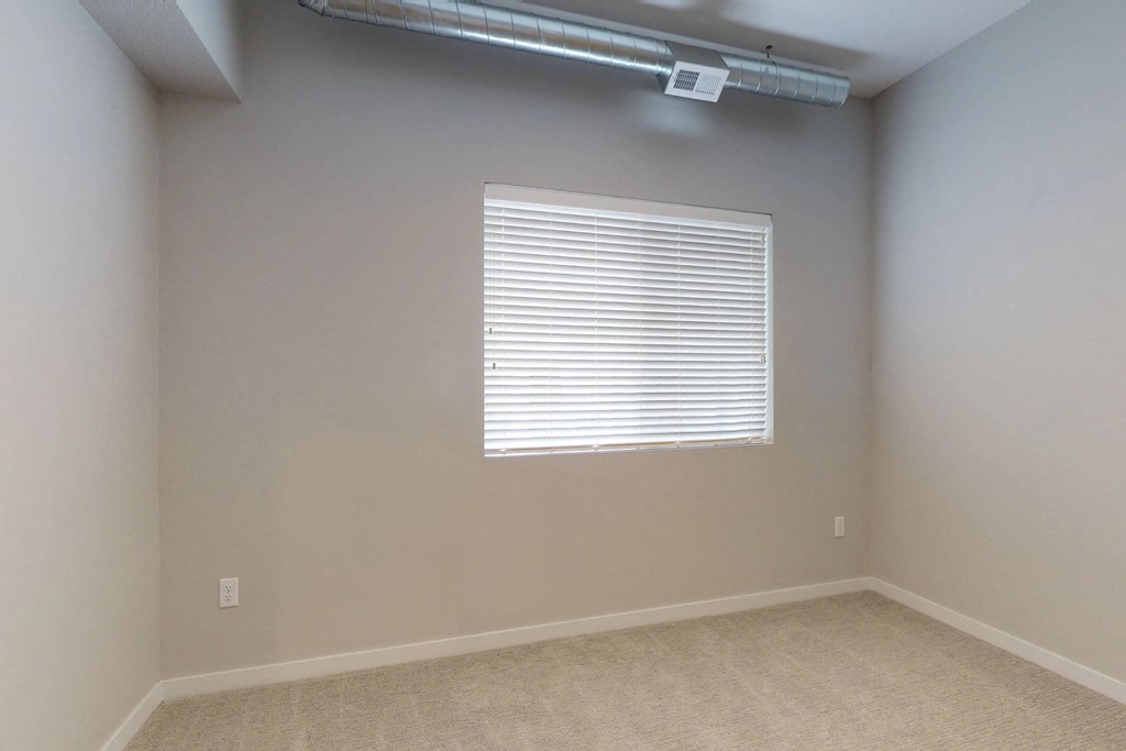 a room with a window and a beige carpet at Vue Apartments, Iowa, 50309