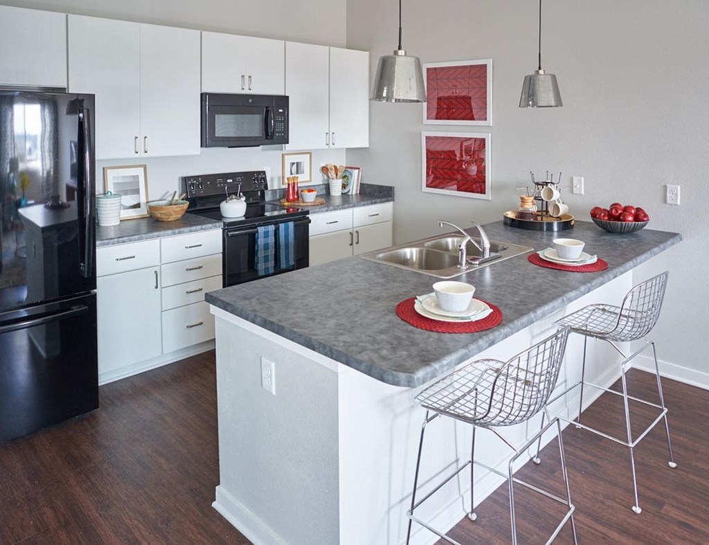 a kitchen with an island and a table with chairs at Vue Apartments, Iowa