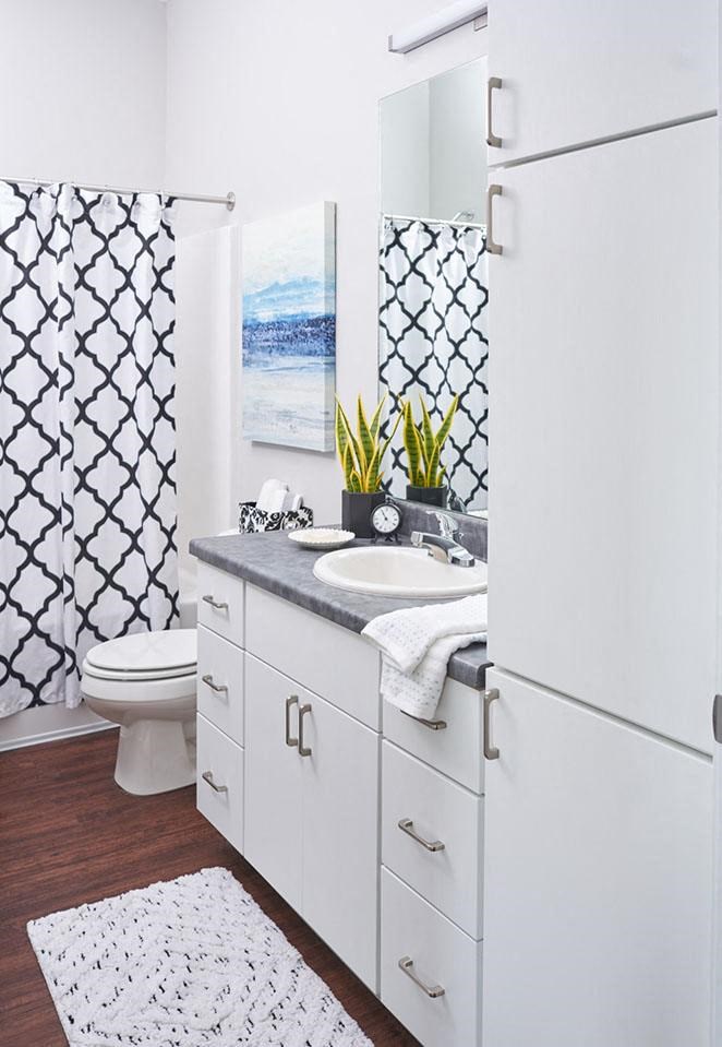 a white bathroom with a sink and a toilet at Vue Apartments, Iowa