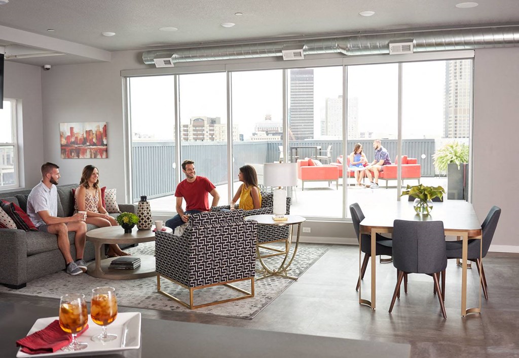 A group of people are sitting in a modern living room at Vue Apartments, Des Moines