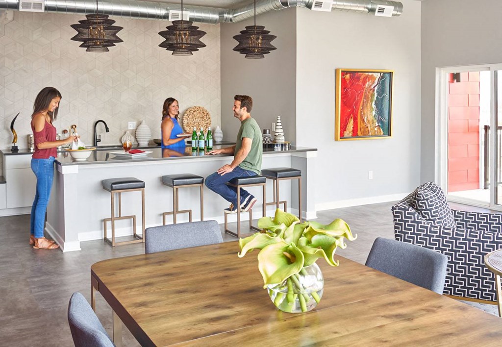 people in a living room and kitchen with a table and chairs at Vue Apartments, Des Moines, IA 50309