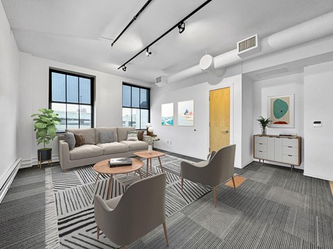 A modern living room with a grey carpet and a brown chair.