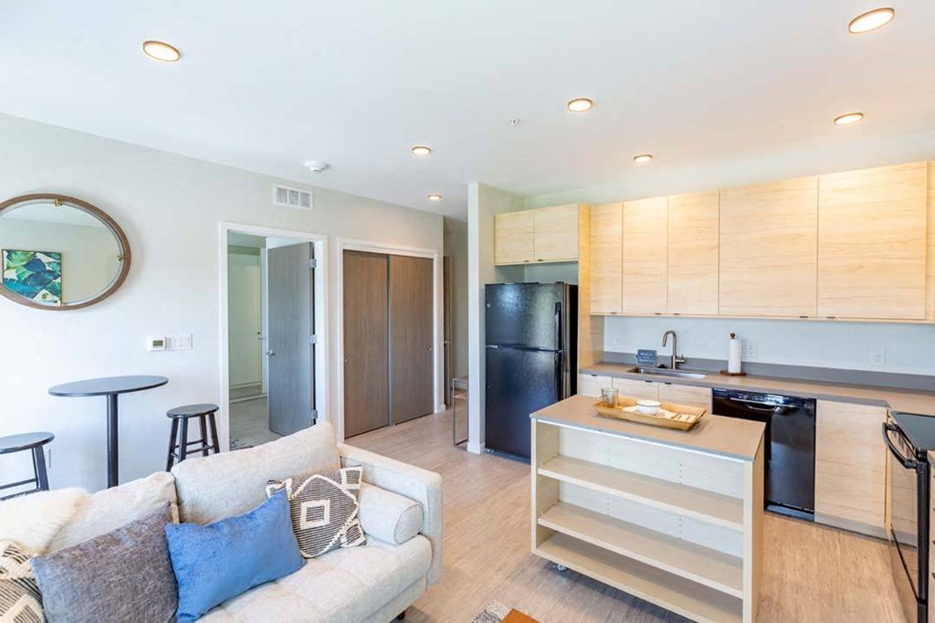 a living room with a couch and a kitchen a living room with a couch and a kitchen at Rowat Lofts, Des Moines, 50309