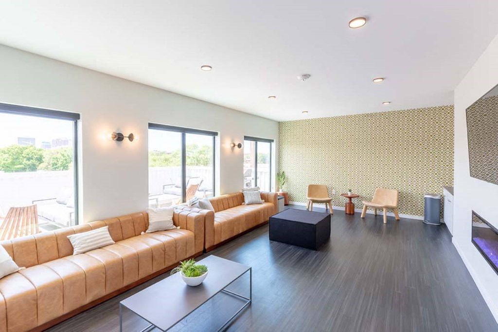 a living room with leather couches and a table at Rowat Lofts, Des Moines, 50309  