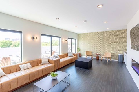 A living room with a brown sofa and a black coffee table.