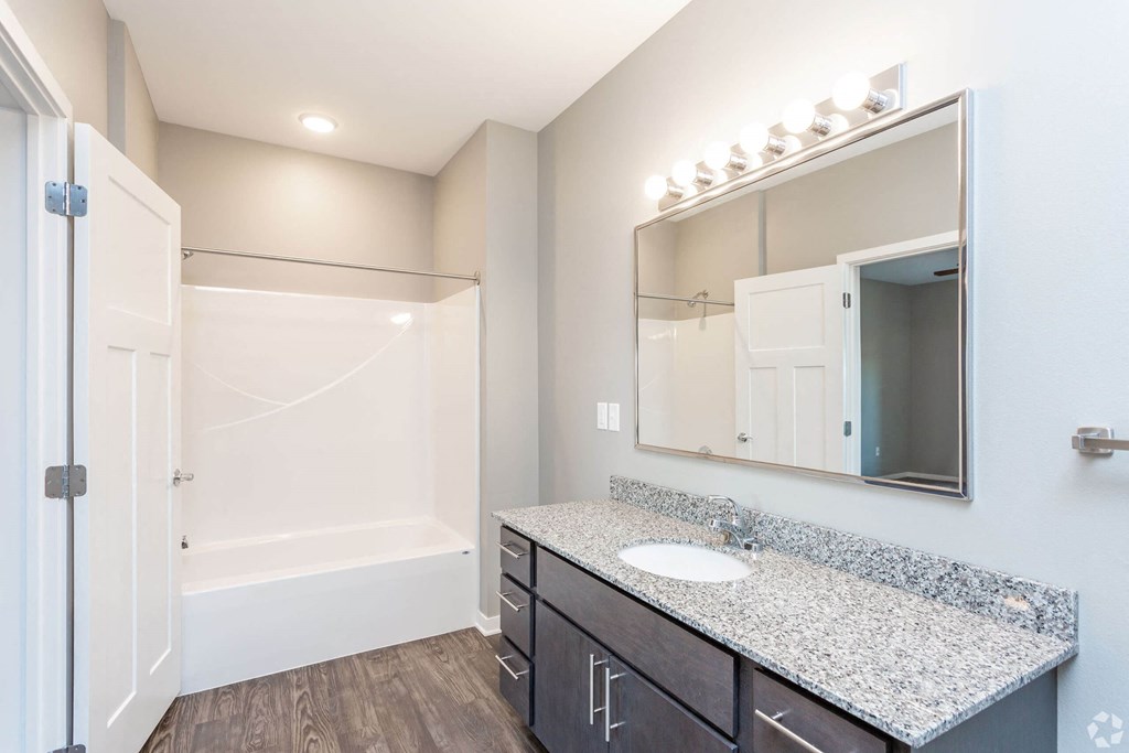 A bathroom with a white tub and sink. at The Barclay Apartments, IOWA, 50009