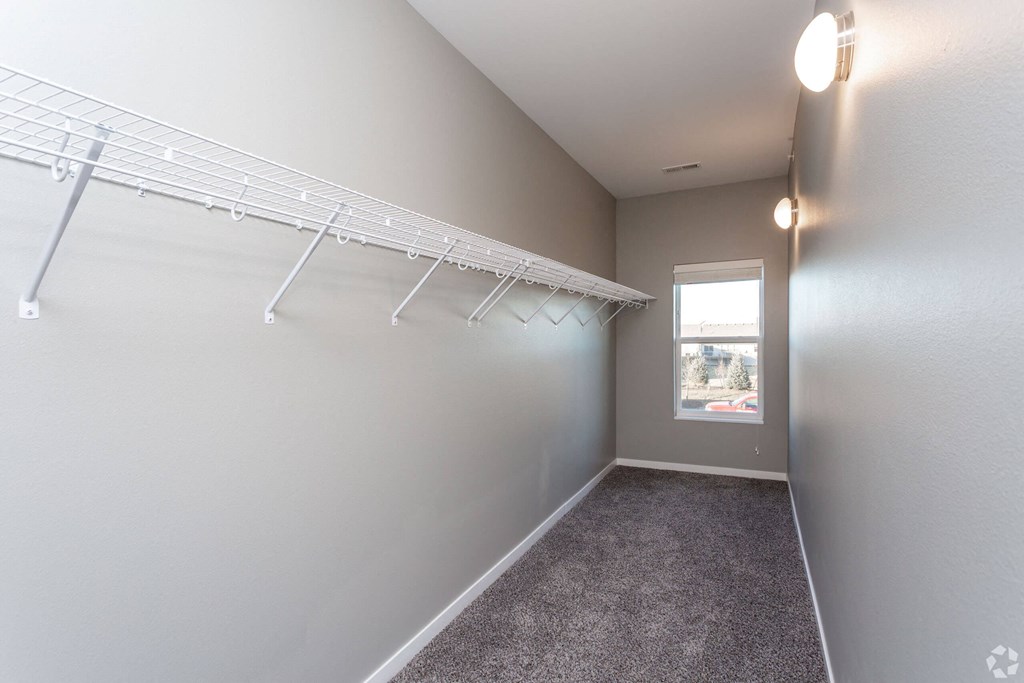 an empty closet with white shelves and a window at The Barclay Apartments, Altoona