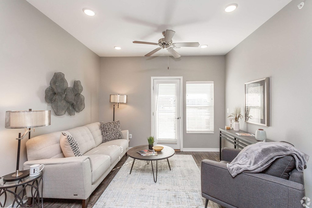 a living room with a couch and a ceiling fan at The Barclay Apartments, Altoona, 50009