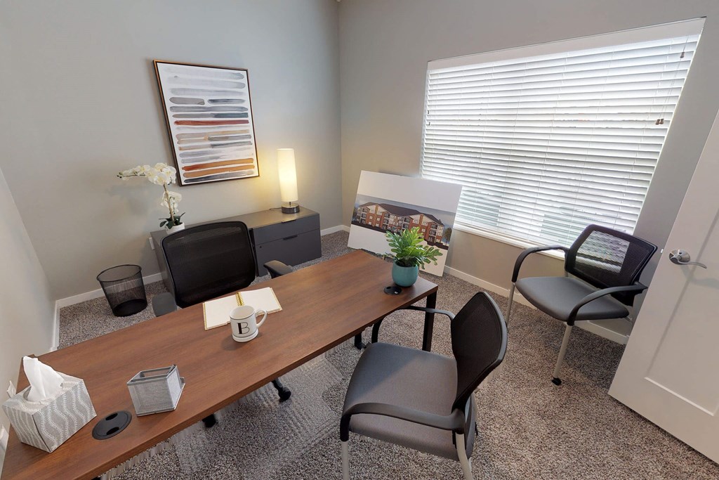A conference room with a long table, chairs, and a framed picture on the wall. at The Barclay Apartments, Altoona, IOWA