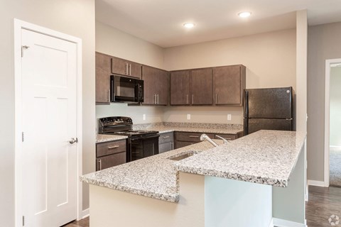 A kitchen with a white counter top and brown cabinets.