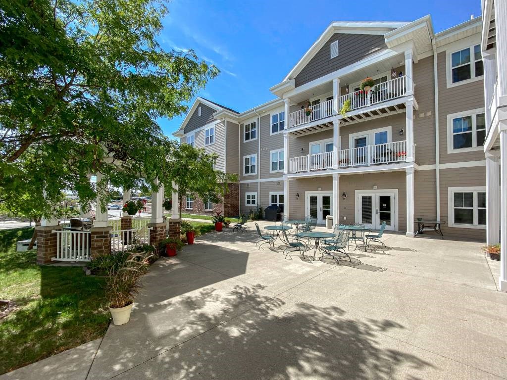 A sunny day at the outdoor patio of a multi-story apartment building.at Cornerstone Commons, Johnston, 50131  
