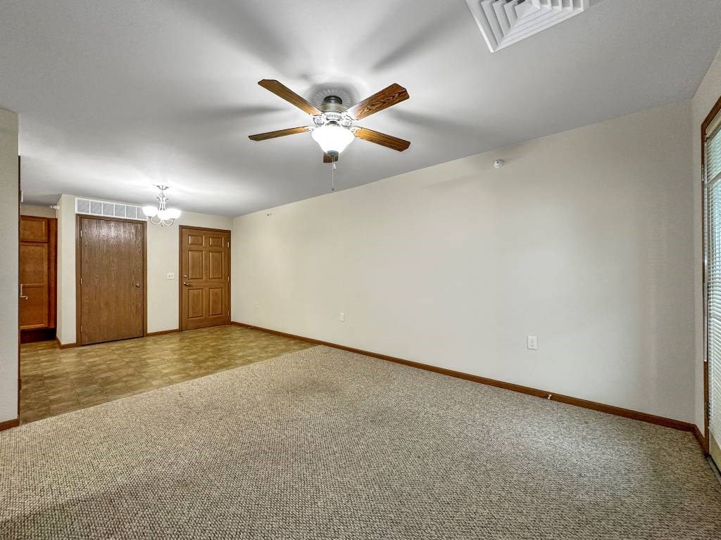 A room with a ceiling fan and carpeted floor.at Cornerstone Commons, Iowa, 50131