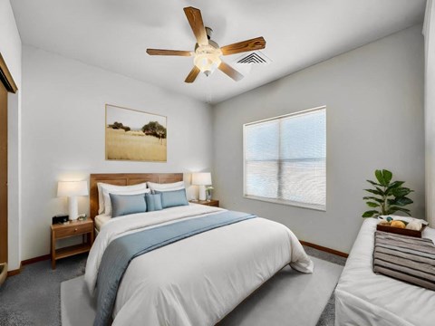A bedroom with a large bed and a ceiling fan.