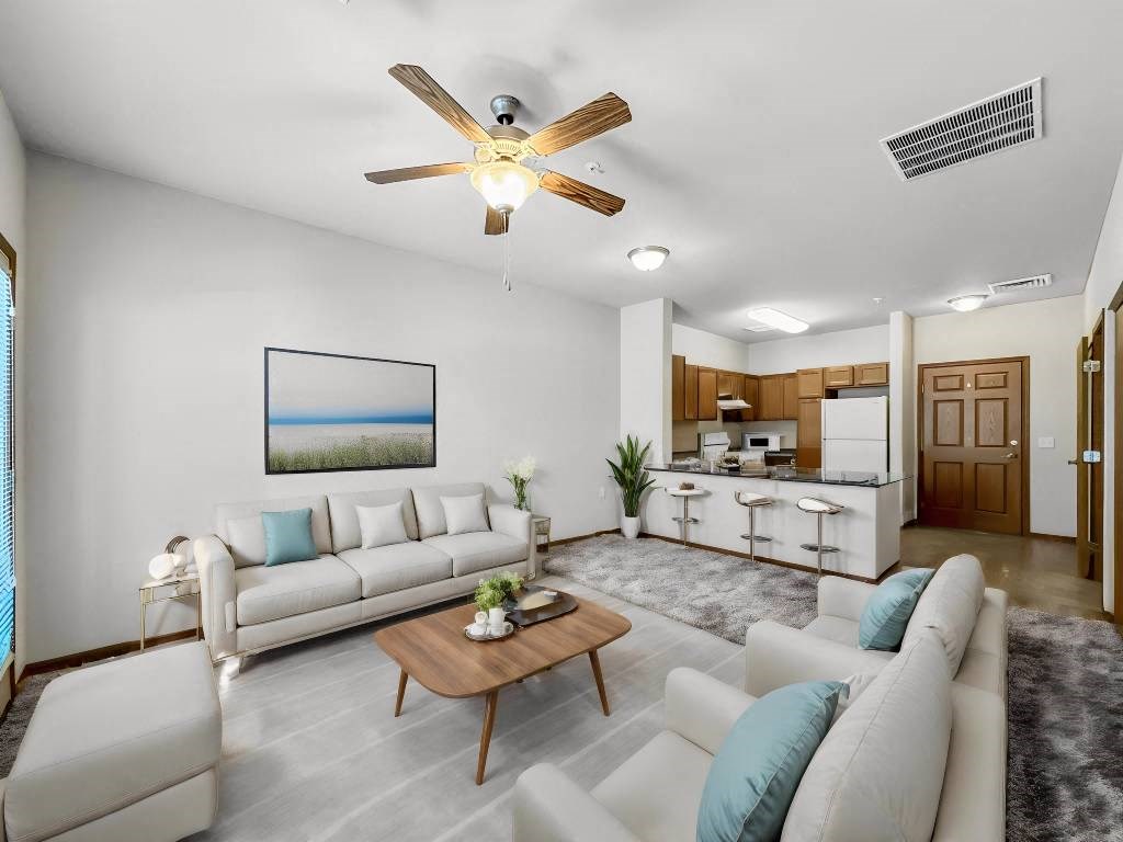A living room with a white couch, a coffee table, and a ceiling fan. A living room with a white couch, a coffee table, and a ceiling fan.at Cornerstone Commons, Johnston, IA 50131