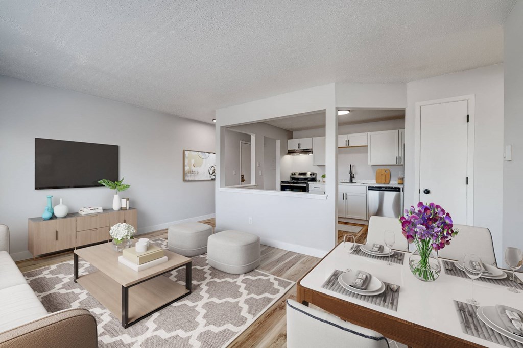 A modern living room with a white sofa, a coffee table, and a dining table set for two. A modern living room with a white sofa, a coffee table, and a dining table set for two at The Hampton Meadows Apartments, Iowa, 50315