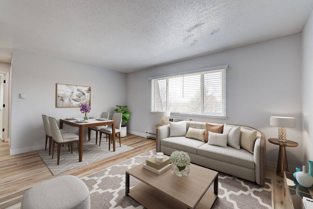 A well-lit living room with a dining table and a couch at The Hampton Meadows Apartments,Des Moines, Iowa