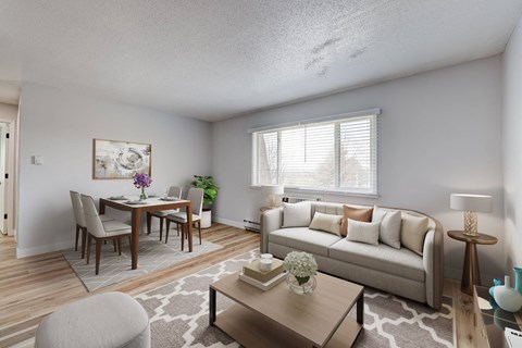 A living room with a grey couch, a coffee table, a dining table with chairs, and a painting on the wall.