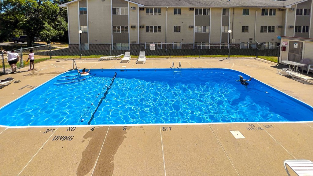 A large blue swimming pool in front of a building A large blue swimming pool in front of a building at The Ridges Apartments, IA, 50315