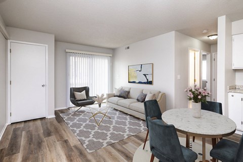 A living room with a white couch, a grey rug, and a round table with chairs.at Fish Creek, Iowa  