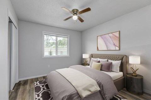 A bedroom with a bed, pillows, a ceiling fan, and a window.at Fish Creek, Norwalk, 50211