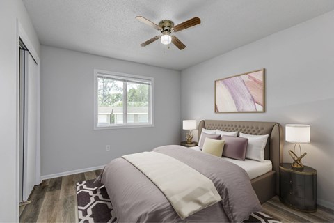 A bedroom with a bed, pillows, a ceiling fan, and a window.at Fish Creek, Norwalk, IA  