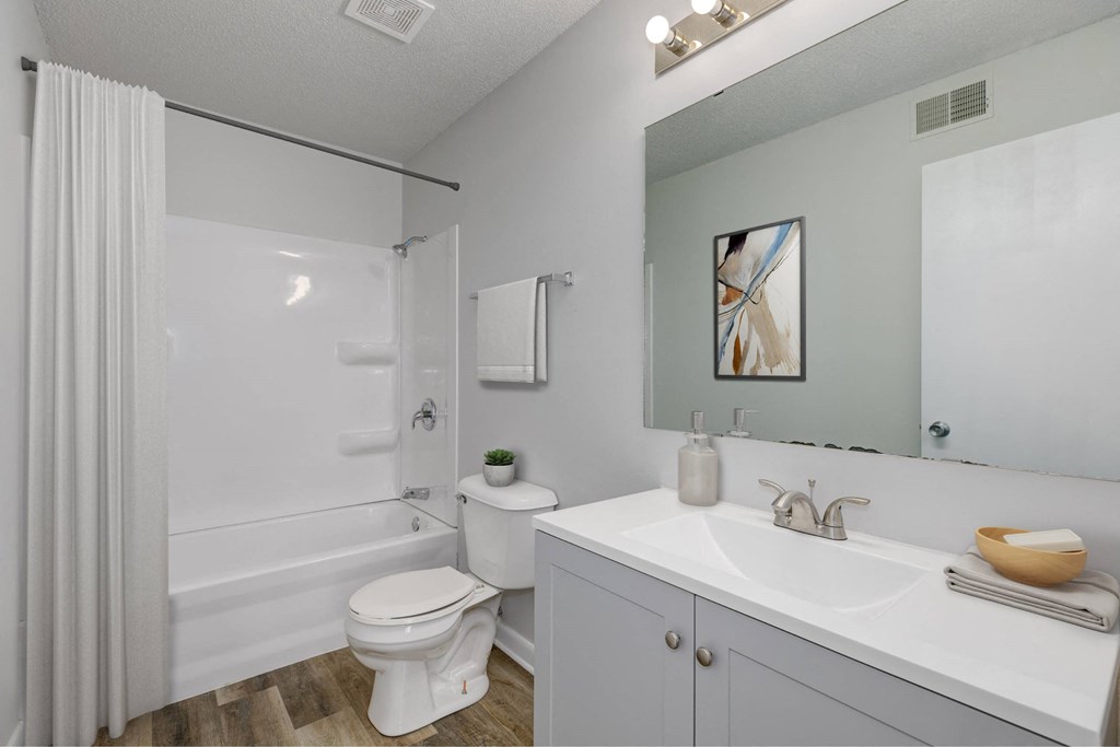 A white bathroom with a toilet, sink, and shower. A white bathroom with a toilet, sink, and shower.at Fish Creek, Norwalk, IA