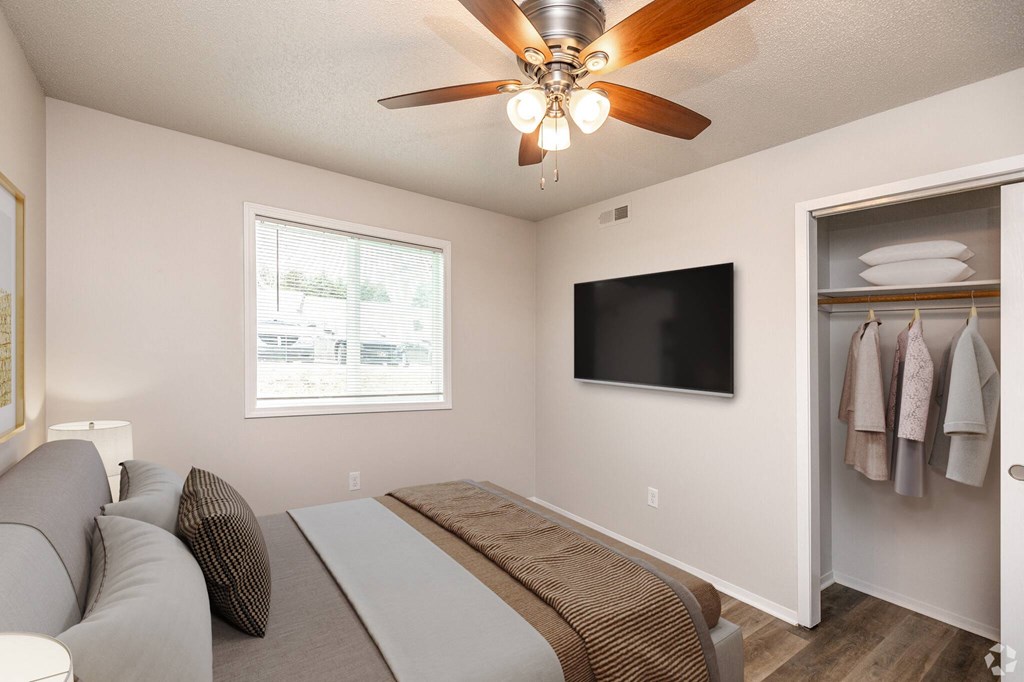 A bedroom with a bed, a television, and a window.at Fish Creek, Norwalk Iowa  