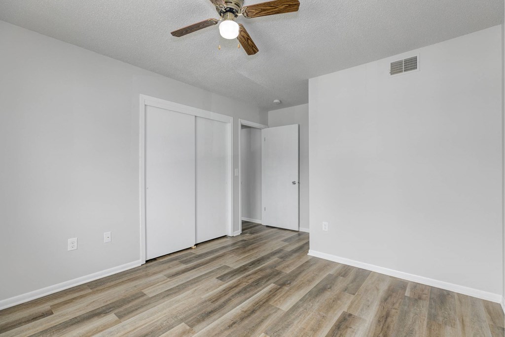 A room with a ceiling fan and wooden flooring.at Fish Creek, Iowa, 50211