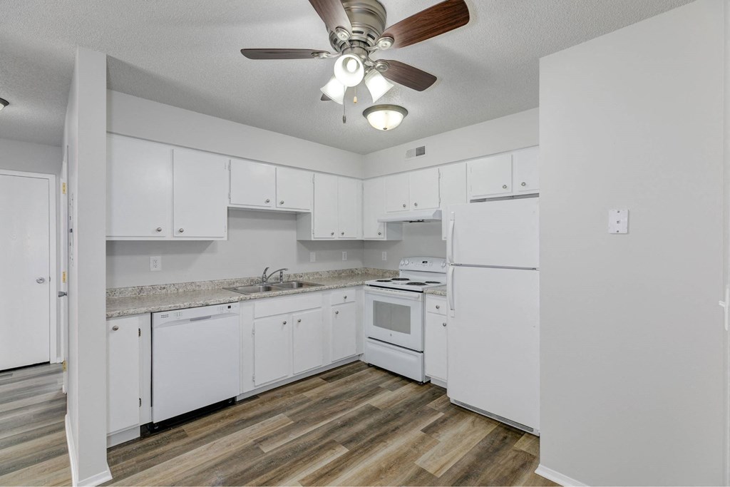A kitchen with white cabinets and a wood floor.at Fish Creek, Norwalk  