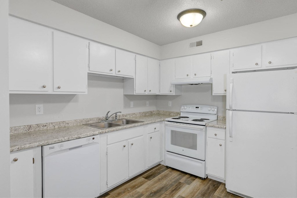 A white kitchen with a sink, stove, and refrigerator.at Fish Creek, Norwalk, IA 50211  
