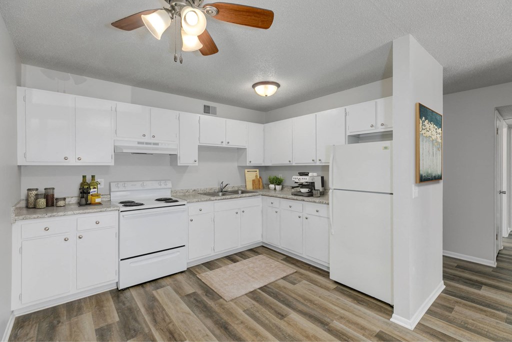 A kitchen with white cabinets and a wood floor.at Fish Creek, Norwalk, 50211  