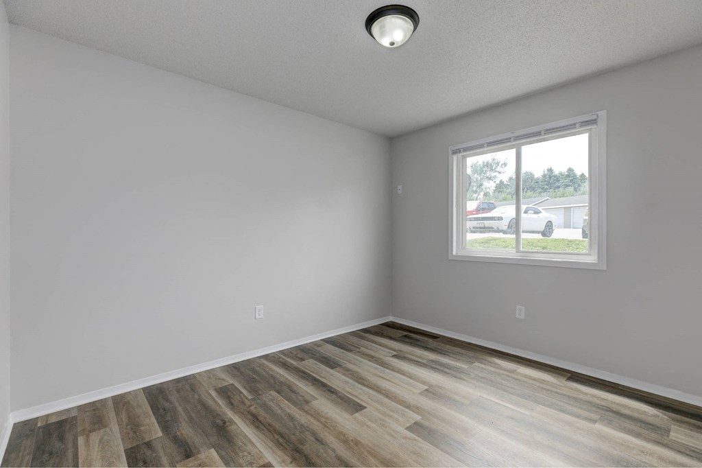 A room with a window and wooden flooring.at Fish Creek, Iowa  