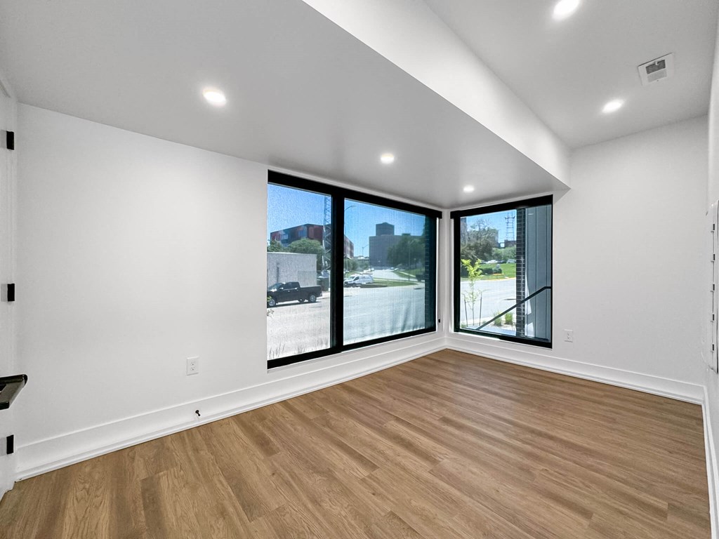 an empty living room with large windows and wood floors  at Matilda 235 Townhomes, Des Moines, 50309