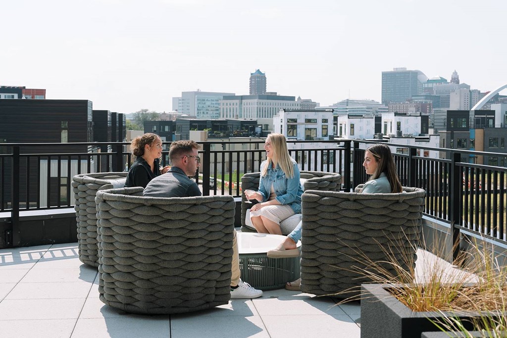 Four people sitting on a rooftop terrace.at Level, Iowa   
