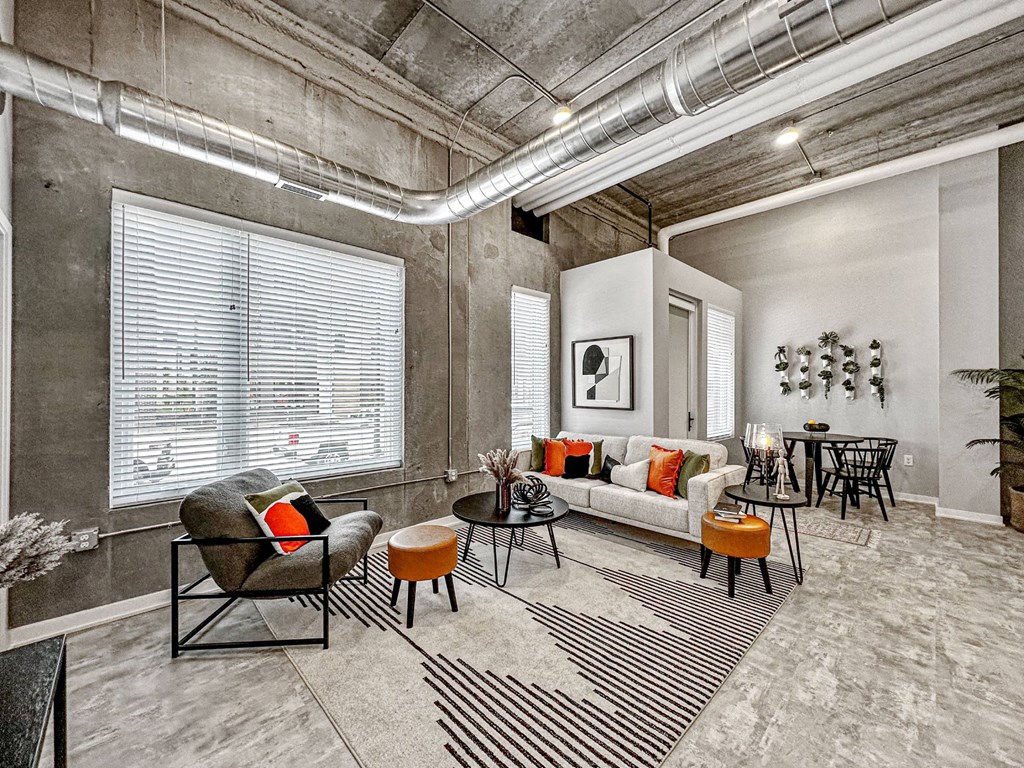 A living room with a grey couch, a black chair, and a black and white striped rug.at Level, Des Moines, IA 50309  
