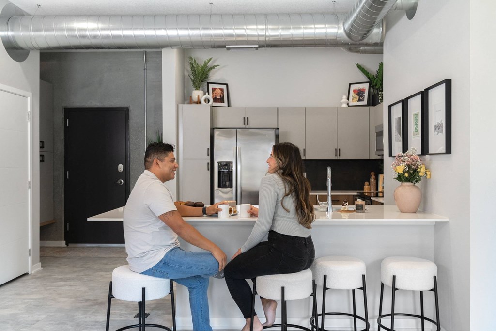 A man and a woman are sitting at a kitchen island.at Level, Des Moines, IA  