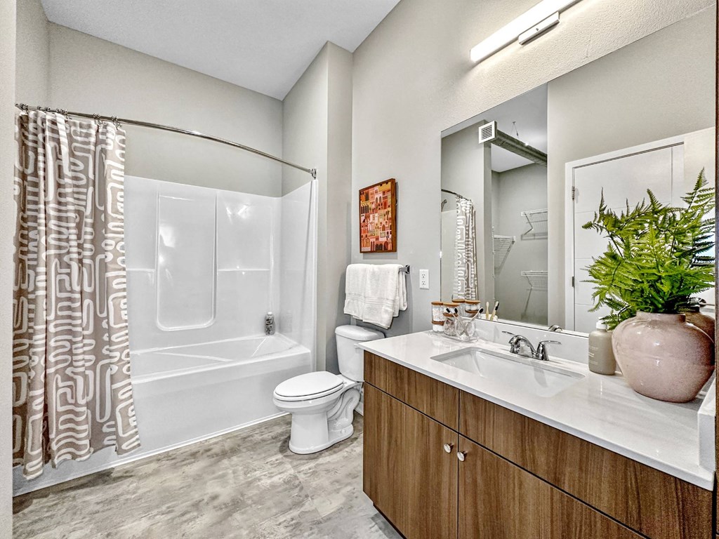 A bathroom with a toilet, sink, and shower.at Level, Des Moines, IA 50309  