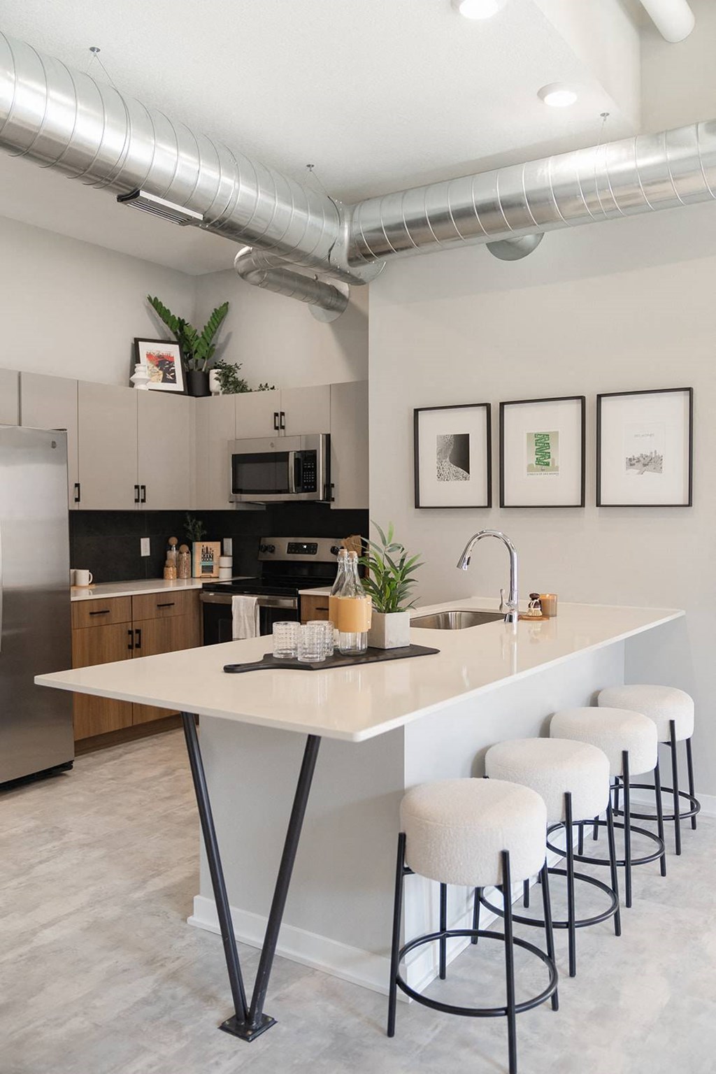A kitchen with a white counter and stools.at Level, Iowa, 50309