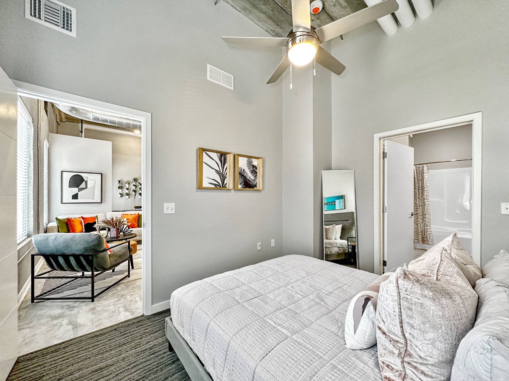 A bedroom with a bed, a chair, and a ceiling fan.at Level, Des Moines, IA  