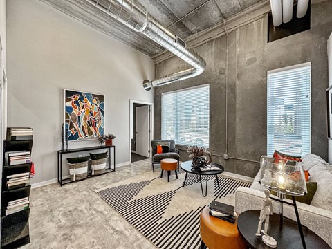 A living room with a large painting on the wall and a striped rug on the floor.