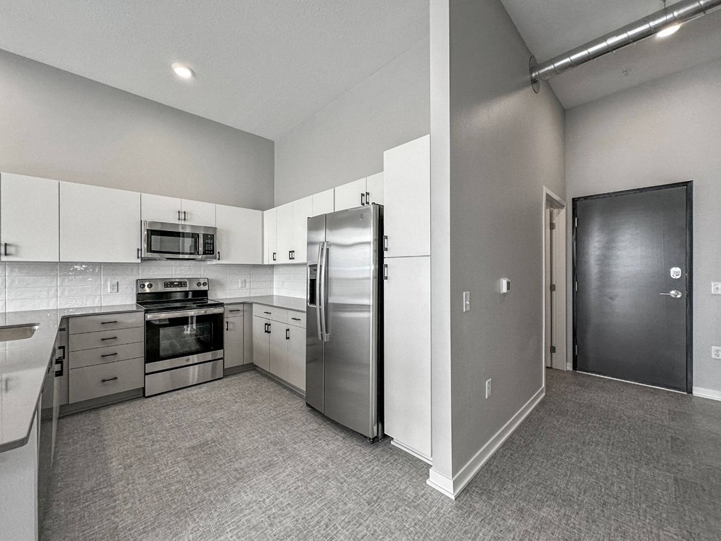 A kitchen with a refrigerator, oven, and microwave.at Level, Des Moines Iowa   