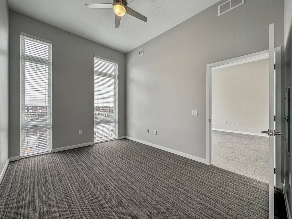 A room with a ceiling fan and carpeted floor.at Level, Des Moines, IA 50309  