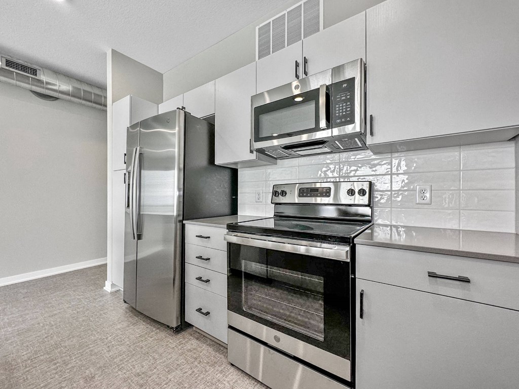 A modern kitchen with stainless steel appliances and white cabinets.at Level, Iowa   