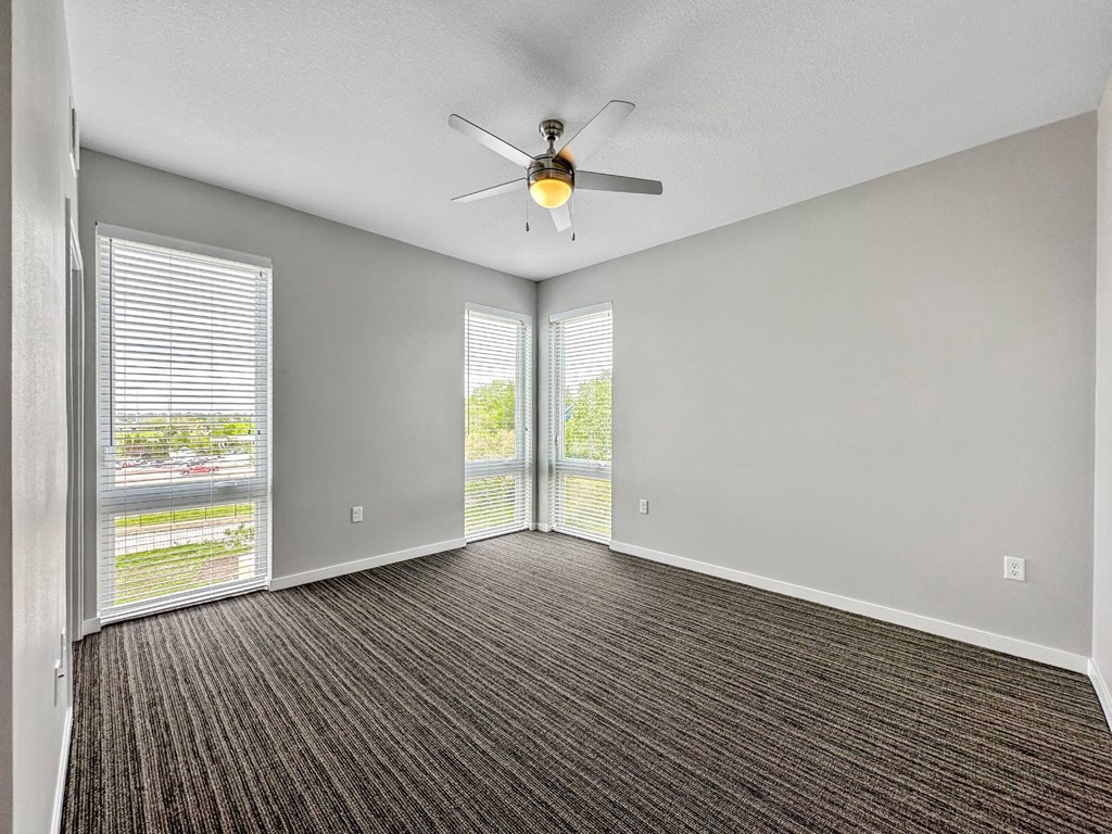 A room with a ceiling fan and carpeted floor.at Level, Des Moines, IA  
