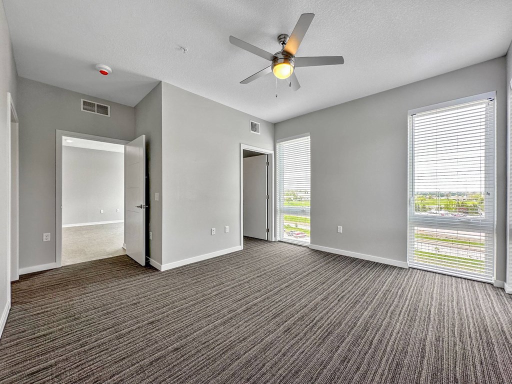 A room with a ceiling fan and carpeted floor.at Level, Des Moines, IA 50309  