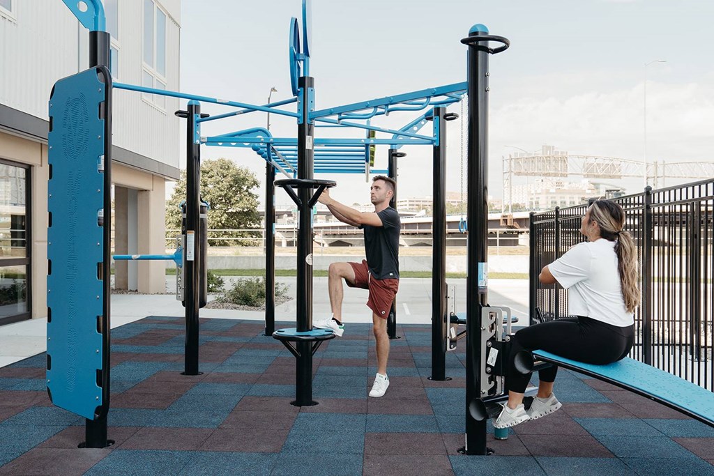 A man and a woman are exercising at a park.at Level, Des Moines  